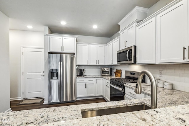 433 Parker Station Ave, Fuquay Varina, NC 27526 - kitchen featuring appliances with stainless steel finishes, light stone countertops, white cabinets, backsplash, and recessed lighting
