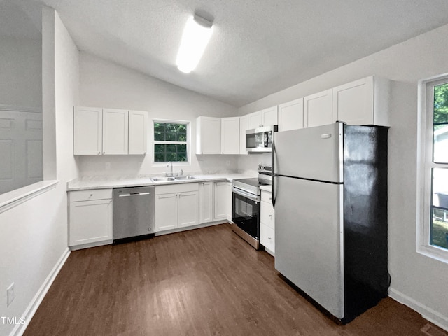 216 E Hinton St, Clayton, NC 27520 - kitchen featuring stainless steel appliances, a sink, lofted ceiling, dark wood-type flooring, and white cabinetry