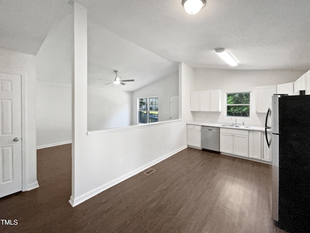 216 E Hinton St, Clayton, NC 27520 - kitchen featuring stainless steel appliances, vaulted ceiling, dark wood-style floors, white cabinetry, and baseboards
