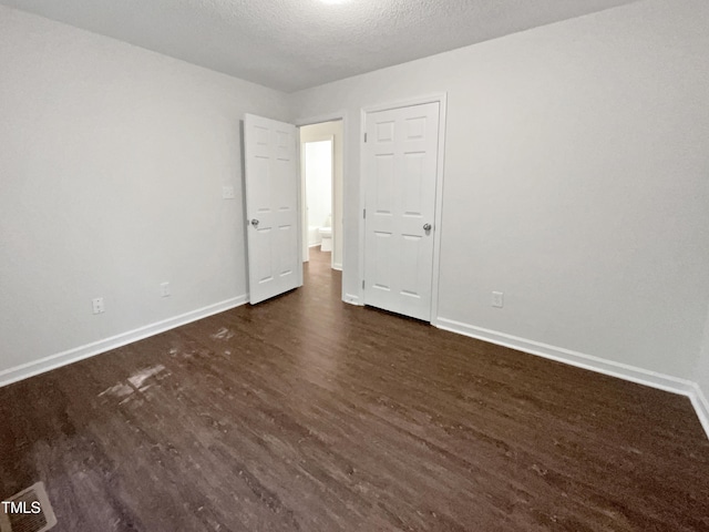 216 E Hinton St, Clayton, NC 27520 - spare room featuring dark wood-style flooring, baseboards, and a textured ceiling
