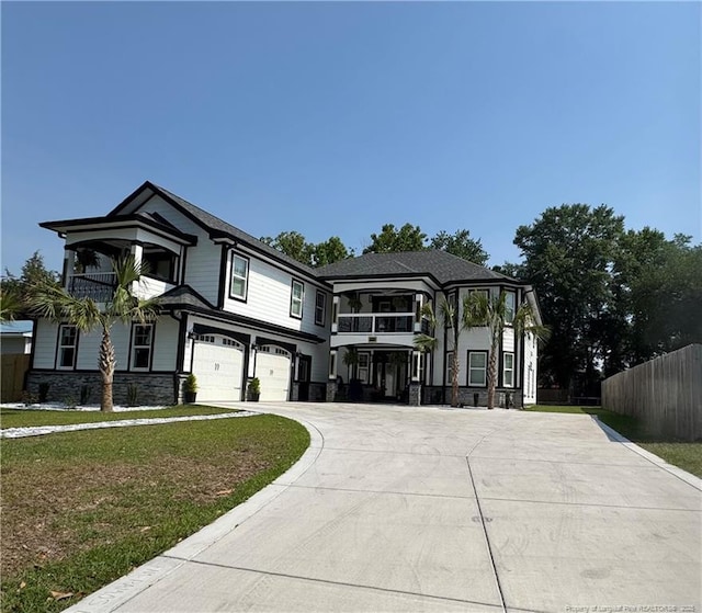 504 E Edinborough Ave, Raeford, NC 28376 - view of front of home with a garage, curved driveway, a balcony, and stone siding