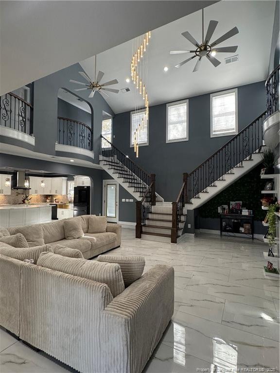 504 E Edinborough Ave, Raeford, NC 28376 - living room with a ceiling fan, high vaulted ceiling, stairway, marble finish floors, and arched walkways