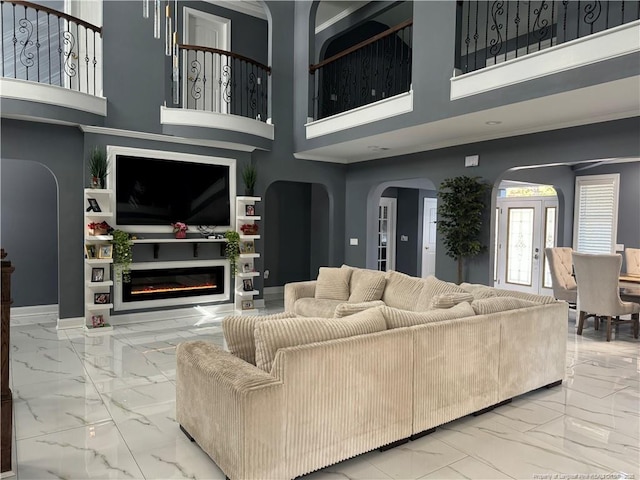 504 E Edinborough Ave, Raeford, NC 28376 - living area featuring marble finish floors, arched walkways, a high ceiling, a glass covered fireplace, and baseboards