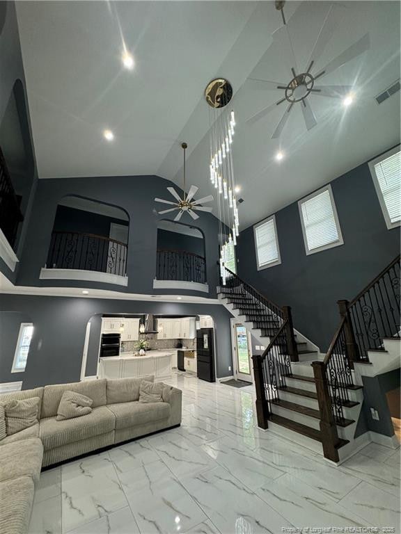 504 E Edinborough Ave, Raeford, NC 28376 - living room featuring a ceiling fan, high vaulted ceiling, stairway, light marble finish flooring, and baseboards