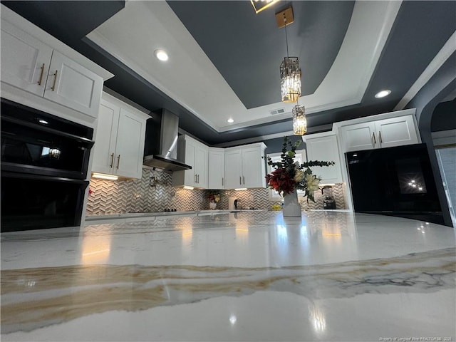 504 E Edinborough Ave, Raeford, NC 28376 - detailed view of wall chimney exhaust hood, decorative backsplash, a chandelier, white cabinetry, and light stone countertops