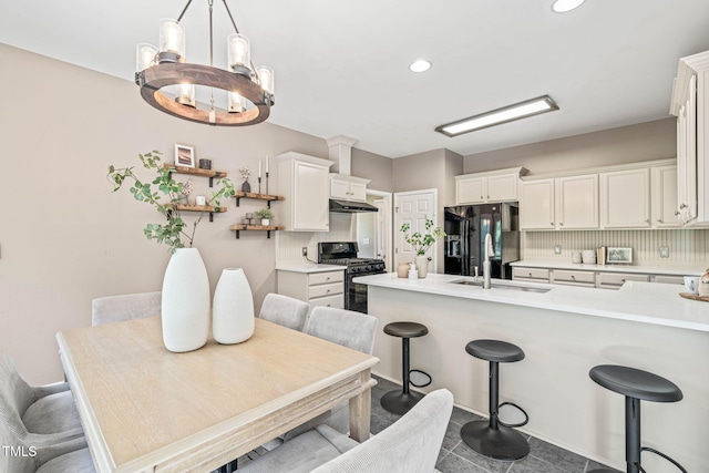 1717 Ormond Rd, Hurdle Mills, NC 27541 - kitchen featuring black appliances, a breakfast bar area, a sink, open shelves, and white cabinets