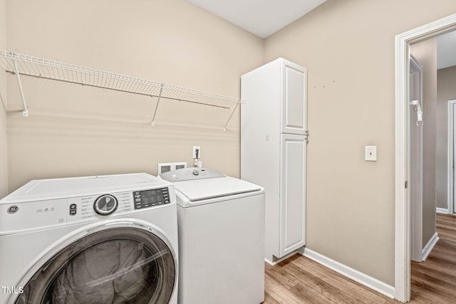 1717 Ormond Rd, Hurdle Mills, NC 27541 - laundry area with washer and clothes dryer, cabinet space, light wood-style flooring, and baseboards