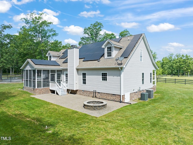 1717 Ormond Rd, Hurdle Mills, NC 27541 - rear view of house with a fire pit, a patio, a sunroom, solar panels, and central AC