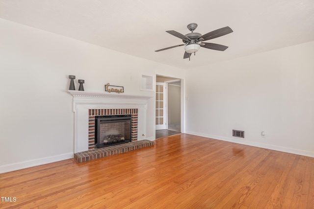 408 N Stewart St, Clayton, NC 27520 - unfurnished living room with wood finished floors, a ceiling fan, baseboards, and a brick fireplace