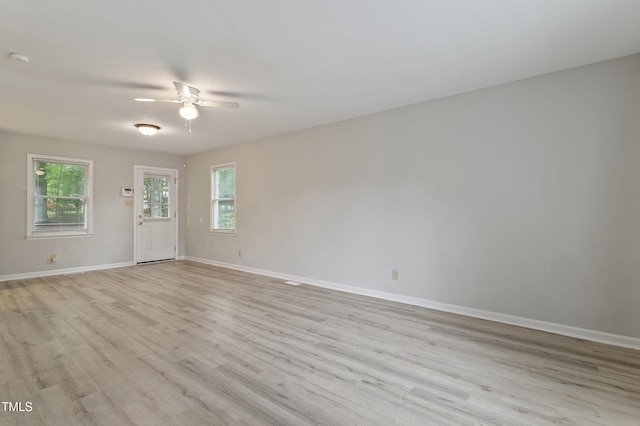 empty room featuring a ceiling fan, wood finished floors, baseboards, and a smoke detector