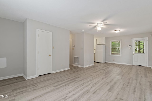 unfurnished living room with ceiling fan, light wood-style floors, and baseboards