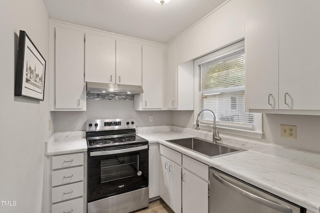 kitchen with appliances with stainless steel finishes, a sink, under cabinet range hood, white cabinets, and a textured ceiling