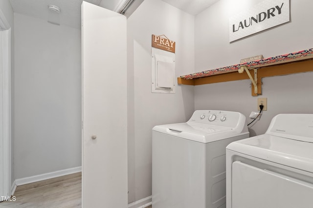 laundry area with washer and clothes dryer, light wood-style flooring, and baseboards