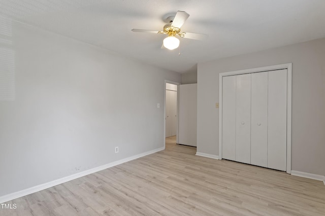 unfurnished bedroom with light wood-type flooring, baseboards, a closet, and ceiling fan