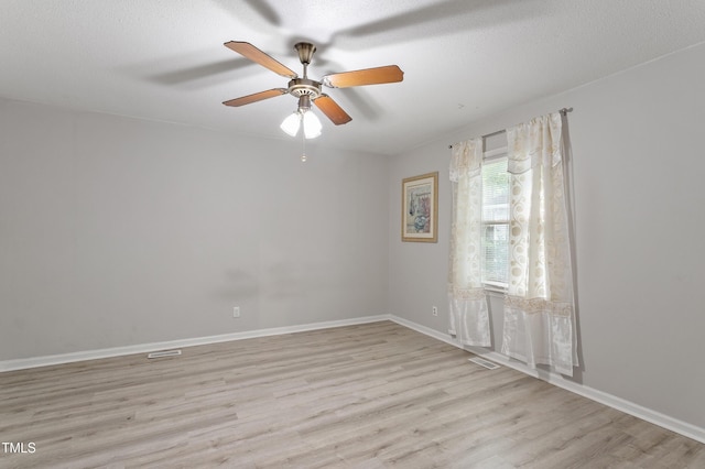 empty room featuring light wood-type flooring, ceiling fan, and baseboards