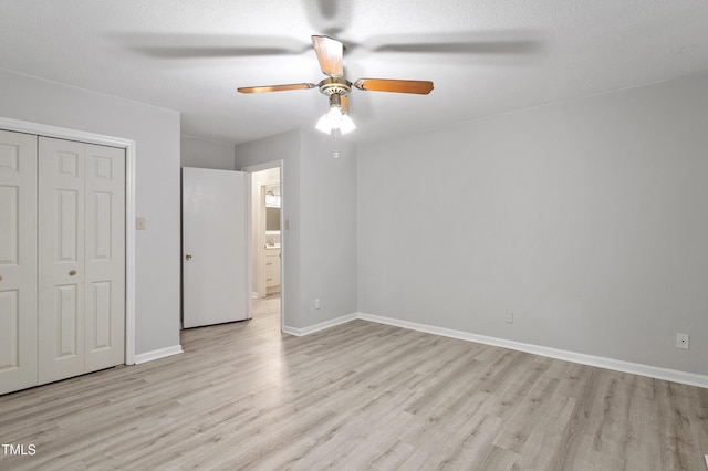 unfurnished bedroom featuring light wood-type flooring, a closet, baseboards, and ceiling fan
