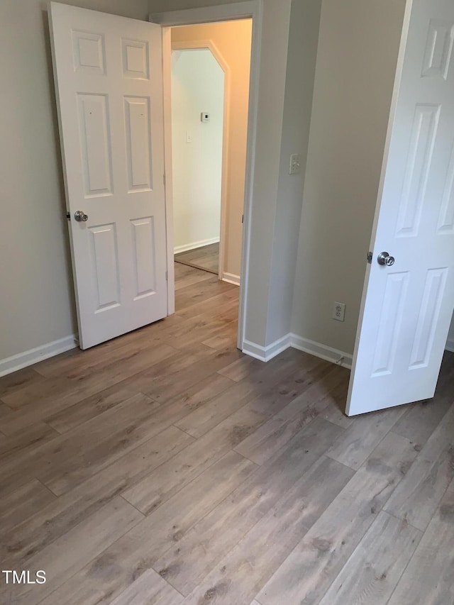2001 Ballston Pl, Knightdale, NC 27545 - unfurnished bedroom featuring wood finished floors, arched walkways, and baseboards