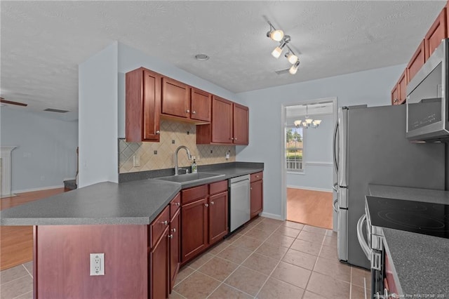 11 Checkmate Ct, Cameron, NC 28326 - kitchen with stainless steel appliances, a sink, dark countertops, light tile patterned floors, and a textured ceiling