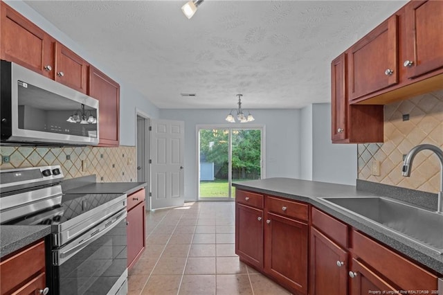 11 Checkmate Ct, Cameron, NC 28326 - kitchen with stainless steel appliances, reddish brown cabinets, dark countertops, and a textured ceiling