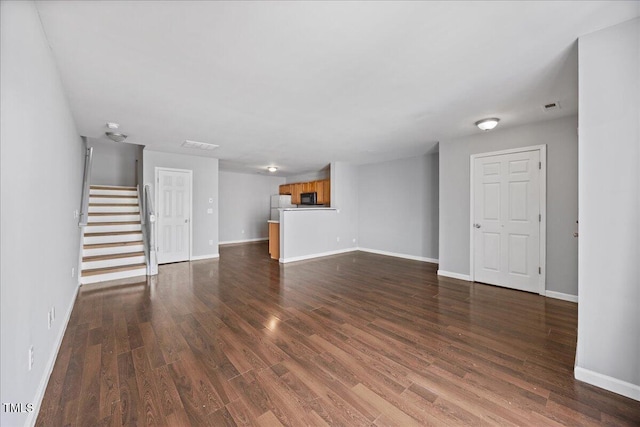 8630 Neuse Lndg Unit 105, Raleigh, NC 27616 - unfurnished living room with dark wood-style floors, stairs, and baseboards