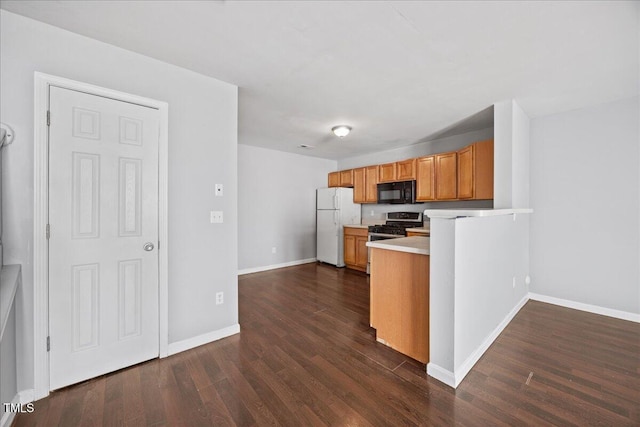 8630 Neuse Lndg Unit 105, Raleigh, NC 27616 - kitchen with black microwave, stainless steel range with gas cooktop, freestanding refrigerator, dark wood-style flooring, and brown cabinetry