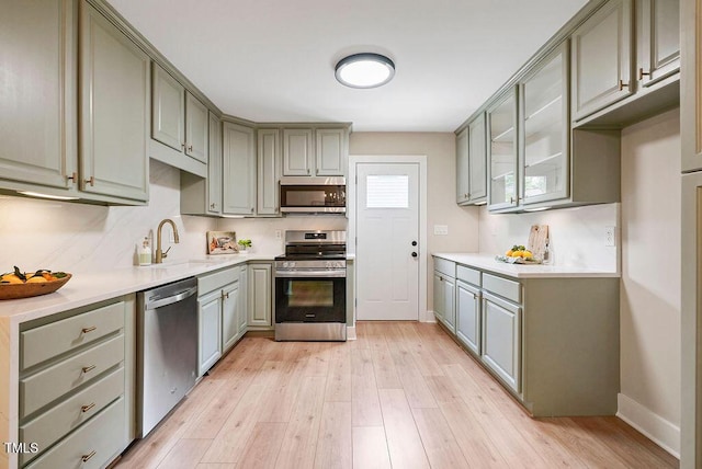 847 E Maple Ln, Fuquay Varina, NC 27526 - kitchen with appliances with stainless steel finishes, gray cabinets, light wood-style flooring, a sink, and baseboards