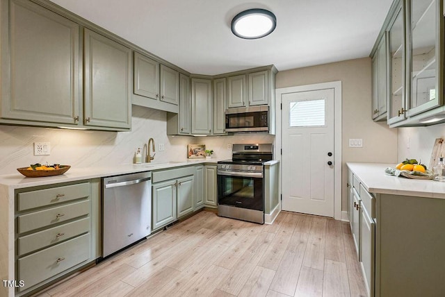 847 E Maple Ln, Fuquay Varina, NC 27526 - kitchen with appliances with stainless steel finishes, a sink, light wood finished floors, and light countertops