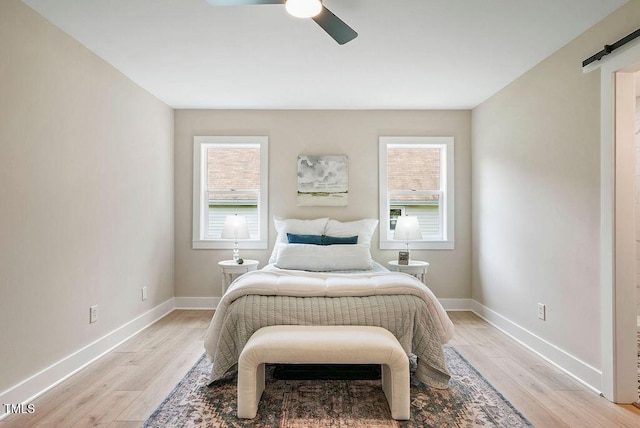 847 E Maple Ln, Fuquay Varina, NC 27526 - bedroom featuring light wood-style floors, baseboards, a barn door, and a ceiling fan