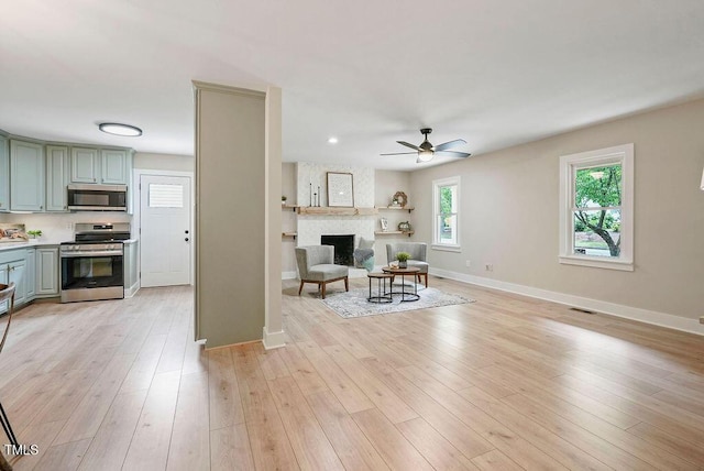 847 E Maple Ln, Fuquay Varina, NC 27526 - living room with a ceiling fan, baseboards, a large fireplace, and light wood finished floors