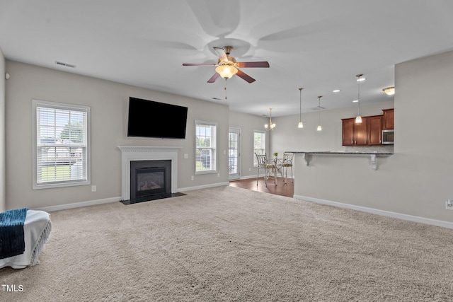 30 Sunbury Ct, Zebulon, NC 27597 - unfurnished living room featuring baseboards, a ceiling fan, carpet floors, and a fireplace with flush hearth