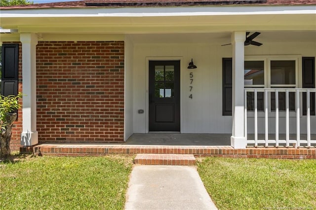 view of exterior entry with brick siding and a porch