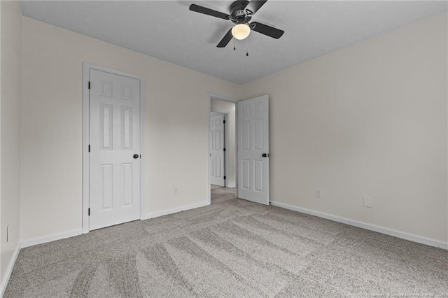 unfurnished bedroom with carpet floors, baseboards, and a ceiling fan