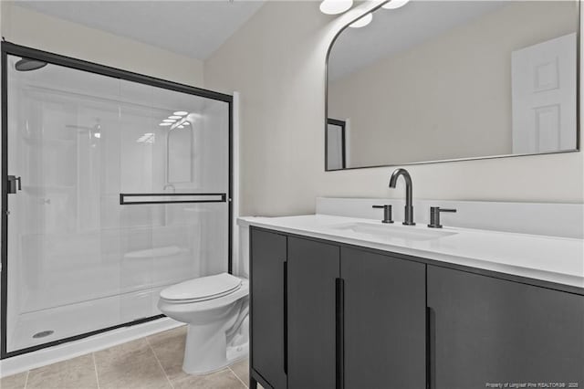bathroom featuring a stall shower, vanity, toilet, and tile patterned flooring
