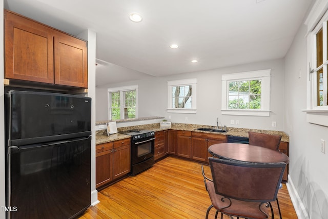 1008 Dorothea Dr, Raleigh, NC 27603 - kitchen with black appliances, a sink, healthy amount of natural light, light wood-style flooring, and recessed lighting