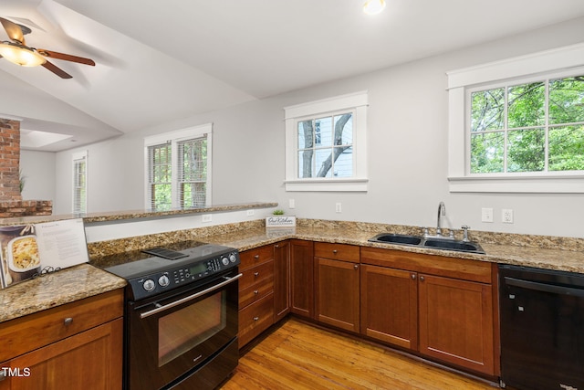 1008 Dorothea Dr, Raleigh, NC 27603 - kitchen featuring black appliances, a sink, light wood-type flooring, light stone counters, and vaulted ceiling