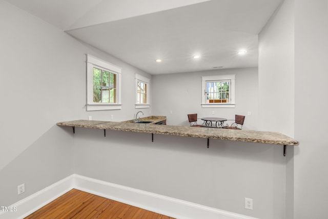 1008 Dorothea Dr, Raleigh, NC 27603 - kitchen featuring a sink, recessed lighting, wood finished floors, baseboards, and a breakfast bar