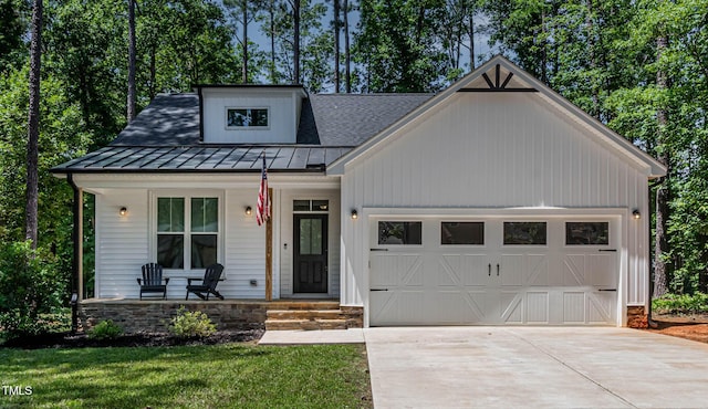 136 Hatchet Cv, Louisburg, NC 27549 - modern farmhouse style home featuring covered porch, a garage, driveway, a standing seam roof, and metal roof