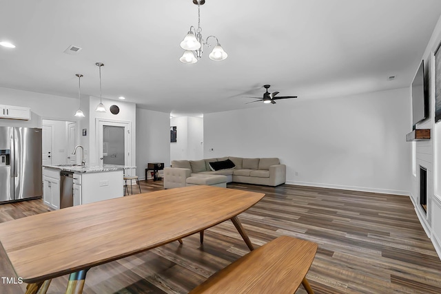 136 Hatchet Cv, Louisburg, NC 27549 - dining area featuring a ceiling fan, dark wood-style flooring, recessed lighting, baseboards, and a large fireplace