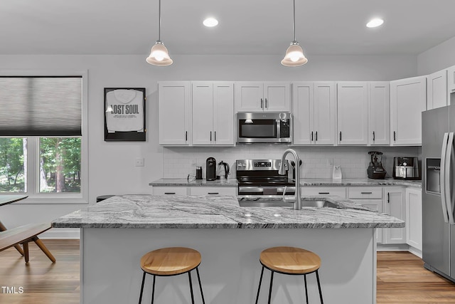 136 Hatchet Cv, Louisburg, NC 27549 - kitchen featuring appliances with stainless steel finishes, a breakfast bar, a sink, decorative backsplash, and recessed lighting
