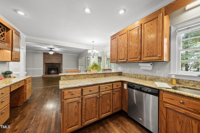 1007 Surry Dale Ct, Apex, NC 27502 - kitchen featuring stainless steel dishwasher, open floor plan, a peninsula, brown cabinetry, and a brick fireplace