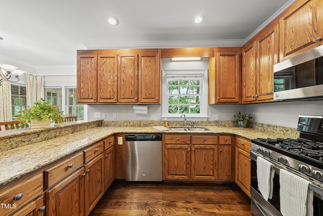 1007 Surry Dale Ct, Apex, NC 27502 - kitchen with stainless steel appliances, a sink, brown cabinetry, light stone countertops, and ornamental molding
