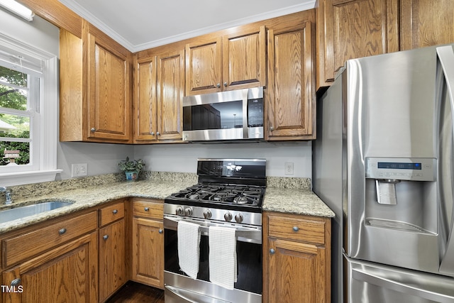 1007 Surry Dale Ct, Apex, NC 27502 - kitchen featuring stainless steel appliances, brown cabinets, a sink, and light stone countertops