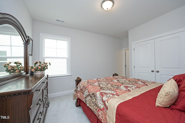 2264 Jollay St, Durham, NC 27703 - bedroom with light carpet, baseboards, multiple windows, and a closet