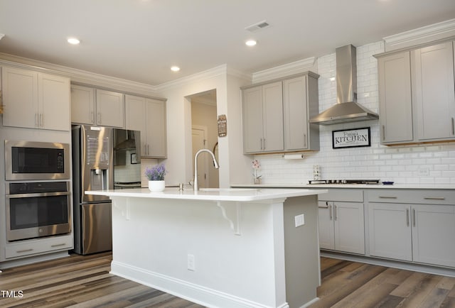 2264 Jollay St, Durham, NC 27703 - kitchen featuring appliances with stainless steel finishes, wall chimney exhaust hood, gray cabinetry, ornamental molding, and decorative backsplash