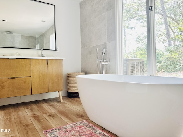 500 Walnut Creek Dr, Goldsboro, NC 27534 - bathroom featuring vanity, a freestanding bath, and wood-type flooring