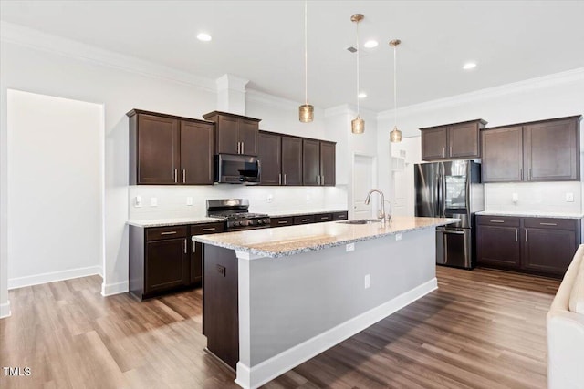 7801 Charters End St, Willow Springs, NC 27592 - kitchen with appliances with stainless steel finishes, a sink, ornamental molding, dark brown cabinets, and backsplash