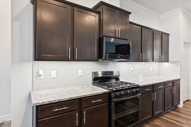 7801 Charters End St, Willow Springs, NC 27592 - kitchen with stainless steel appliances, ornamental molding, light stone countertops, decorative backsplash, and dark brown cabinetry