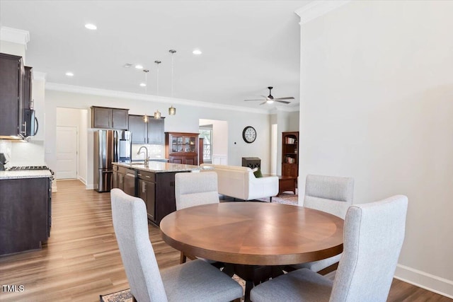 7801 Charters End St, Willow Springs, NC 27592 - dining space with crown molding, a ceiling fan, wood finished floors, recessed lighting, and baseboards