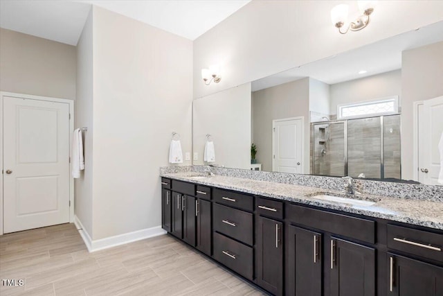 7801 Charters End St, Willow Springs, NC 27592 - bathroom featuring a shower stall, baseboards, double vanity, and wood finished floors
