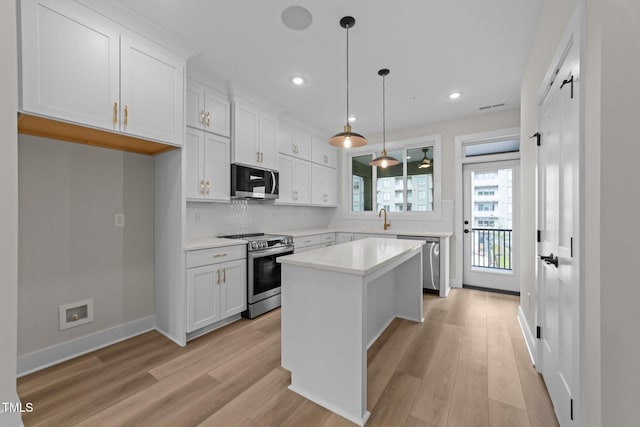 710 W N St Unit 101, Raleigh, NC 27603 - kitchen with appliances with stainless steel finishes, a sink, light wood-style flooring, backsplash, and light countertops